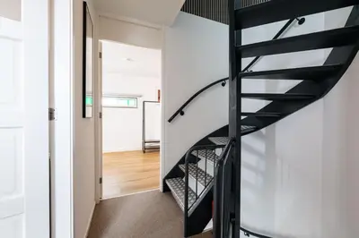 a black spiral staircase in a white house at B&B De Tulpentoren in Roelofarendsveen