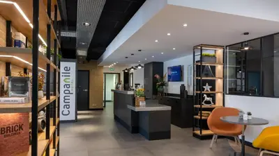 a lobby of a coffee shop with a table and chairs at Campanile Hotel & Restaurant Amsterdam Zuid-Oost in Amsterdam