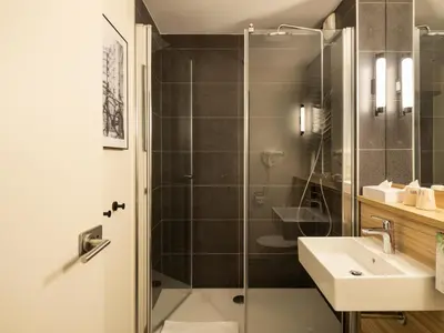 a bathroom with a glass shower and a sink at Campanile Hotel & Restaurant Amsterdam Zuid-Oost in Amsterdam