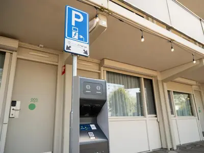 a parking meter with a parking sign in front of a building at Campanile Hotel & Restaurant Amsterdam Zuid-Oost in Amsterdam