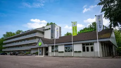 a building with two flags in front of it at Campanile Hotel & Restaurant Amsterdam Zuid-Oost in Amsterdam
