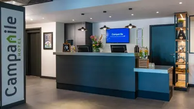a lobby with a blue counter and a tv at Campanile Hotel & Restaurant Amsterdam Zuid-Oost in Amsterdam