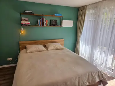 a bed in a bedroom with a green wall at Eco lodge Utrecht Leidsche Rijn in Utrecht