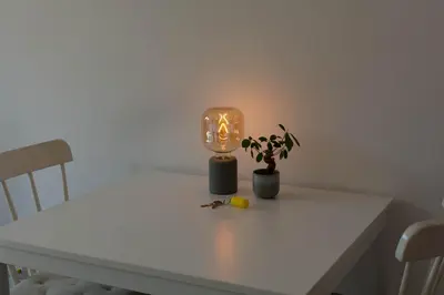 a white table with a candle and a plant on it at Eco lodge Utrecht Leidsche Rijn in Utrecht