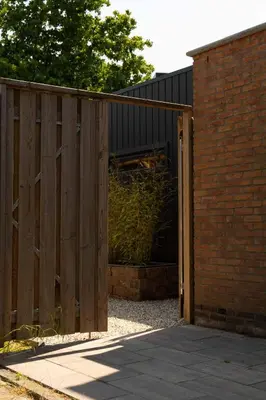 a wooden gate to a building with a brick wall at Eco lodge Utrecht Leidsche Rijn in Utrecht