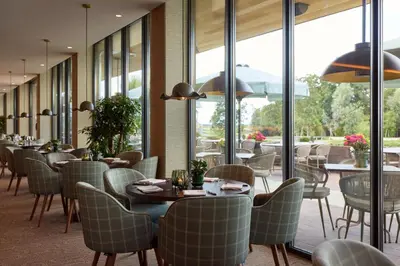 a restaurant with tables and chairs and windows at Van der Valk Hotel Volendam - Recently renovated in Volendam