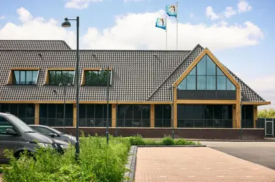 a building with two flags on top of it at Van der Valk Hotel Volendam - Recently renovated in Volendam