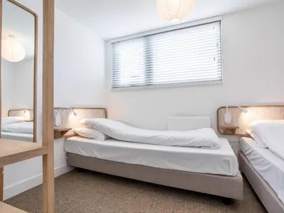 two beds in a room with a window and a mirror at Holiday Home Pieper Luxe by Interhome in Noordwijk