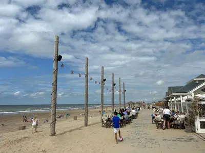 a group of people sitting on the beach at Holiday Home Pieper Luxe by Interhome in Noordwijk