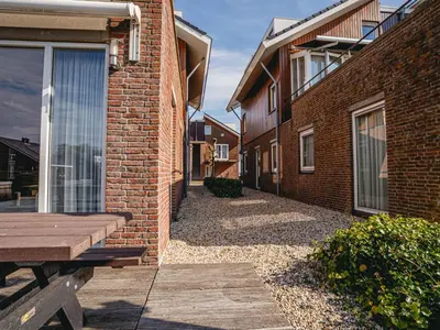 a brick building with a wooden bench next to it at Apartment Westergeest Luxe by Interhome in Uitgeest