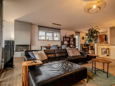 a living room with a black leather couch at NOVA Houseboat DELUXE Free Bikes in Amsterdam