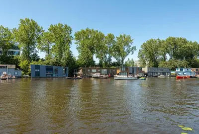 a flooded area with houses and boats in the water at NOVA Houseboat DELUXE Free Bikes in Amsterdam
