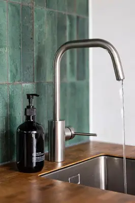 a bottle of soap sitting on a counter next to a sink at Résidence Beaufort in Zandvoort