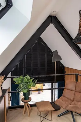 a living room with a chair and a large window at Résidence Beaufort in Zandvoort