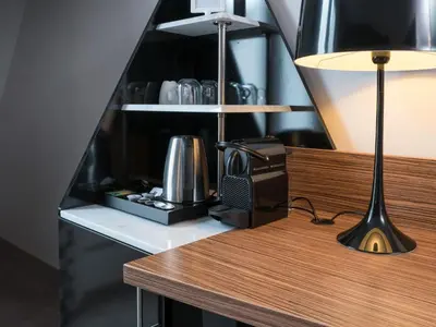 a desk with a lamp and a phone on it at Hotel Woudschoten in Zeist