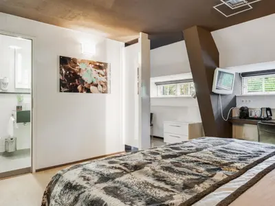 a bedroom with a large bed and a mirror at Hotel Woudschoten in Zeist