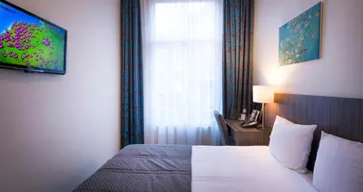 a hotel room with a bed and a window at Hotel Aalders in Amsterdam
