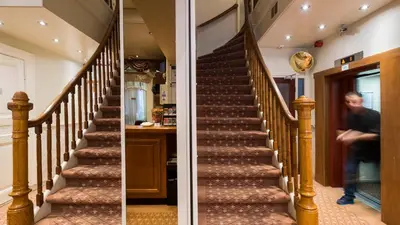 a staircase in a house with a man walking up the stairs at Hotel Aalders in Amsterdam