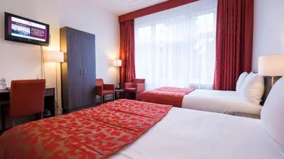 a hotel room with two beds and a window at Hotel Aalders in Amsterdam