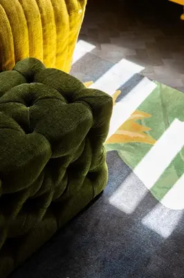 a green couch sitting on the floor in a room at Hotel Aalders in Amsterdam