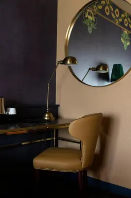 a desk with a chair and a lamp and a mirror at Hotel Aalders in Amsterdam