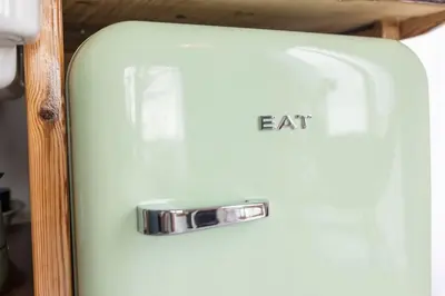 an old white refrigerator with an eat sign on it at De Boterhal - vakantiehuisje op natuurboerderij in Hem