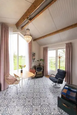 a living room with a table and chairs at De Boterhal - vakantiehuisje op natuurboerderij in Hem