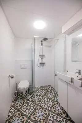 a white bathroom with a toilet and a sink at Groepsaccommodatie op natuurboerderij Huize Blokland in Hem