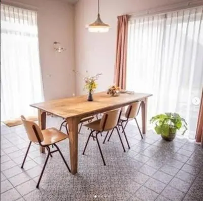 a wooden table with chairs in a room with windows at Groepsaccommodatie op natuurboerderij Huize Blokland in Hem