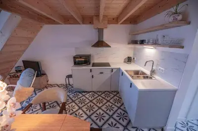 a kitchen with a sink and a table with chairs at Groepsaccommodatie op natuurboerderij Huize Blokland in Hem