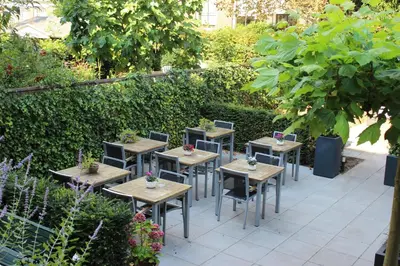 a row of tables and chairs in a garden at Prinsengracht Hotel in Amsterdam