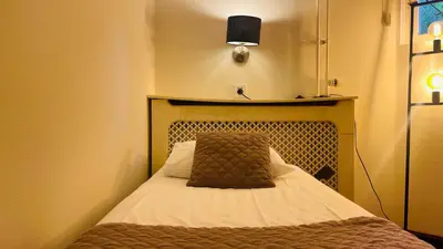 a small room with a bed with a pillow on it at Prinsengracht Hotel in Amsterdam