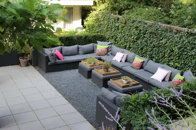 a garden with a blue couch with colorful pillows at Prinsengracht Hotel in Amsterdam