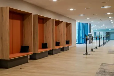 a row of benches in a room with wood dividers at Steigenberger Airport Hotel Amsterdam in Schiphol