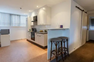 a kitchen with two bar stools and a counter at Hotel de Magneet in Hoorn