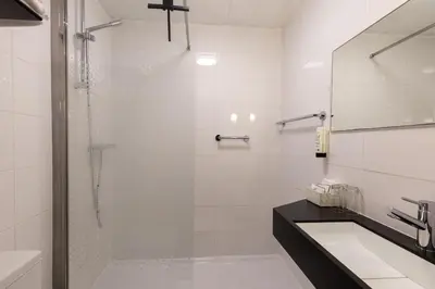 a bathroom with a shower and a sink at Hotel de Magneet in Hoorn