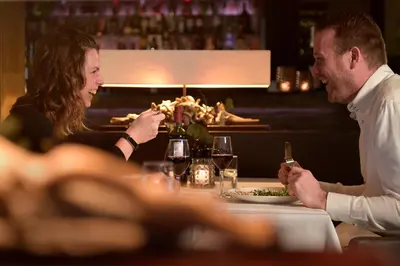 a man and woman sitting at a table with a plate of food at Van der Valk Hotel de Bilt-Utrecht in De Bilt