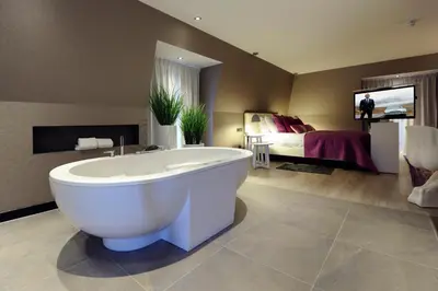a large bathroom with a tub and a bed at Van der Valk Hotel de Bilt-Utrecht in De Bilt