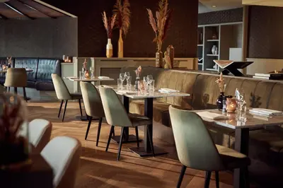 a restaurant with tables and chairs and a bar at Van der Valk Hotel de Bilt-Utrecht in De Bilt