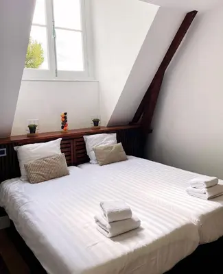 a bedroom with a large bed with two towels on it at Hotel Plantage in Amsterdam