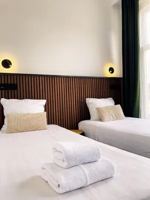 two beds in a hotel room with towels on them at Hotel Plantage in Amsterdam