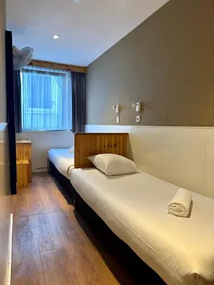 a room with two beds and a window at Hotel Old Quarter in Amsterdam