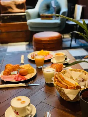 a table with plates of food and cups of coffee at Hotel Old Quarter in Amsterdam