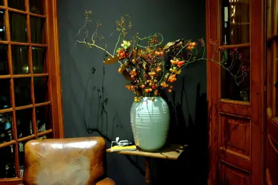 a blue vase sitting on a shelf with flowers in it at Augusta Hotel in IJmuiden
