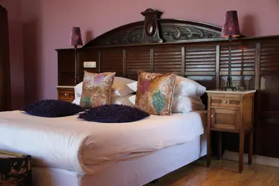 a bedroom with a large bed with a wooden headboard at Augusta Hotel in IJmuiden