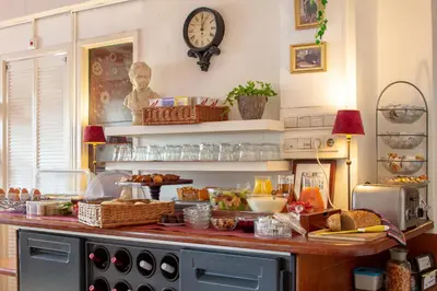 a kitchen with a counter with food and a clock on the wall at Amsterdam House Hotel in Amsterdam
