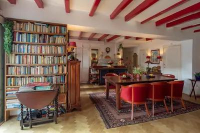 a living room with a table and chairs and bookshelves at Amsterdam House Hotel in Amsterdam