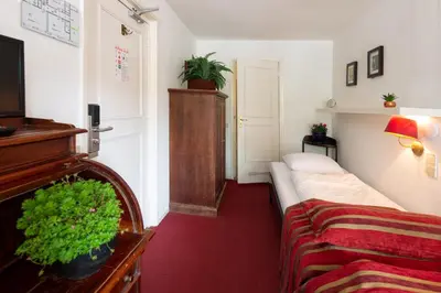 a room with a bed and a tv and a couch at Amsterdam House Hotel in Amsterdam