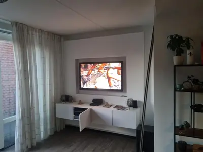 a living room with a television on a wall at Leuke tussenwoning in Hoogkarspel