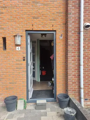 an open door into a brick building at Leuke tussenwoning in Hoogkarspel